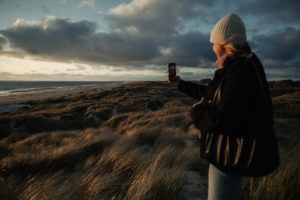 Woman takes a photo of the scenic landscape.