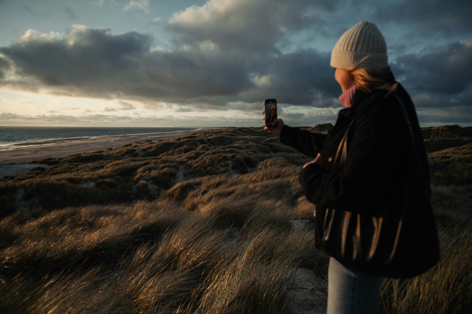 Woman takes a photo of the scenic landscape.